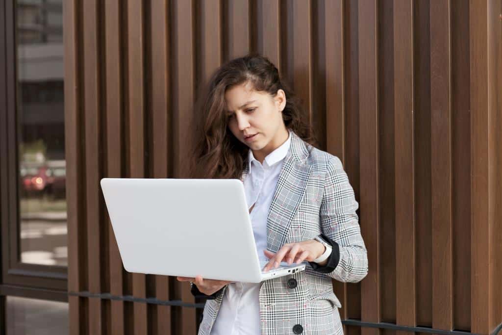 young-millennial-businesswoman-using-laptop-standi-2022