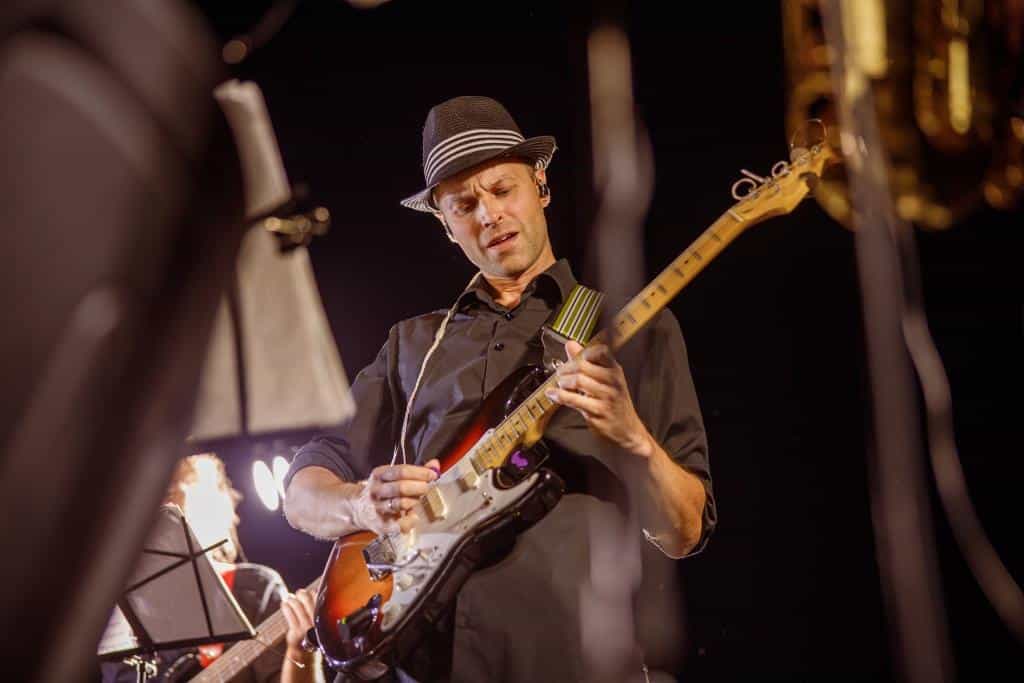 handsome-man-playing-guitar-at-night-outdoor-conce