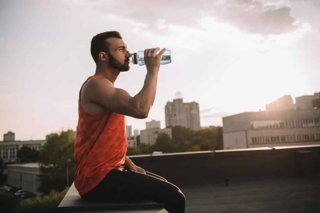 side-view-of-handsome-sportsman-drinking-water-fro-2022