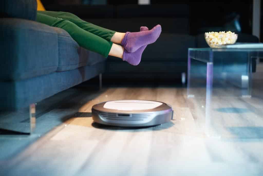 robot-cleaning-floor-while-child-watches-tv-movie