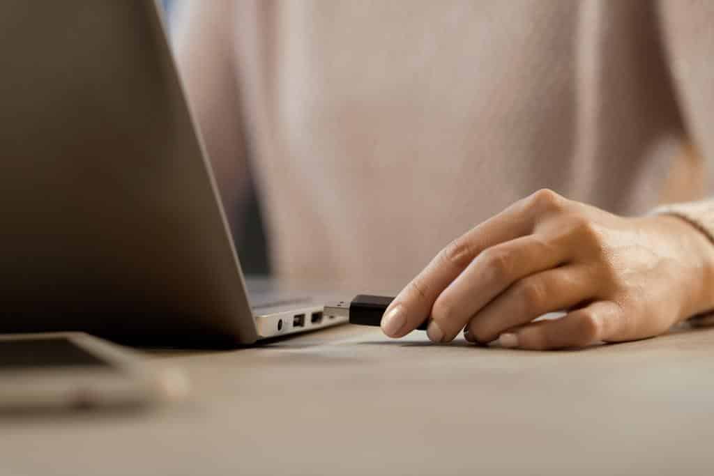 Woman plugging a USB flash drive into her laptop